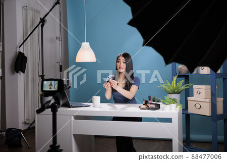 Influencer vlogger recording makeup tutorial presenting lipstick doing review for vlogging channel in studio. Behind the scene of attractive social media creator advertising make up cosmetics 88477006