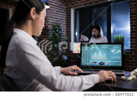 Agency accountant sitting at desk while using laptop to review marketing strategy output. Business company executive manager analyzing management charts and financial graphs in office workspace. Agency accountant sitting at desk while using laptop to review marketing strategy output. Business company executive manager analyzing management charts and financial graphs in office workspace. 88477022