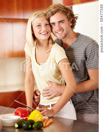 Kitchen romance. Portrait of a happy young couple standing in the kitchen. Kitchen romance. Portrait of a happy young couple standing in the kitchen. 88477388