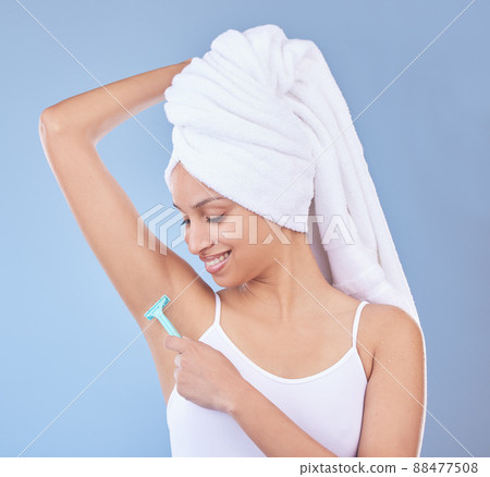 Smooth and fresh. Shot of a young woman using a disposable razor to shave her underarms. 88477508