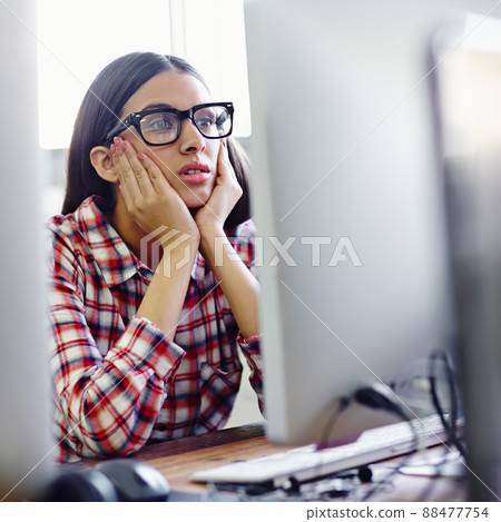 This is getting boring. A young designer looking bored while sitting in front of her computer. This is getting boring. A young designer looking bored while sitting in front of her computer. 88477754