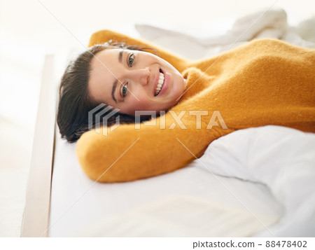 I love my weekends. Cropped portrait of a young woman lying on her bed. 88478402