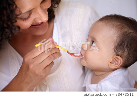 She knows its my favourite flavour. A cute baby girl being fed by her mother. 88478511