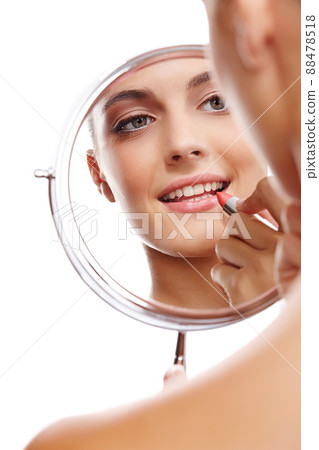 I take pride in my appearance. Over the shoulder studio shot of a beautiful woman applying lipstick reflected in a mirror. I take pride in my appearance. Over the shoulder studio shot of a beautiful woman applying lipstick reflected in a mirror. 88478518