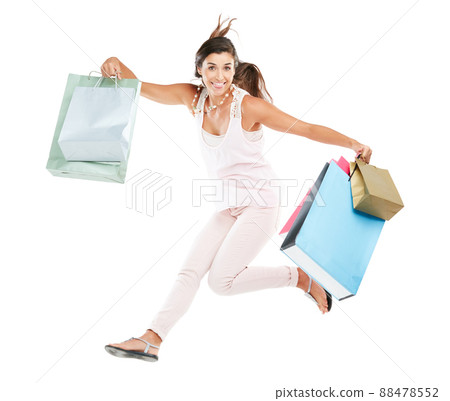 I won a shopping spree. Studio portrait of a happy young woman carrying shopping bags against a white background. 88478552