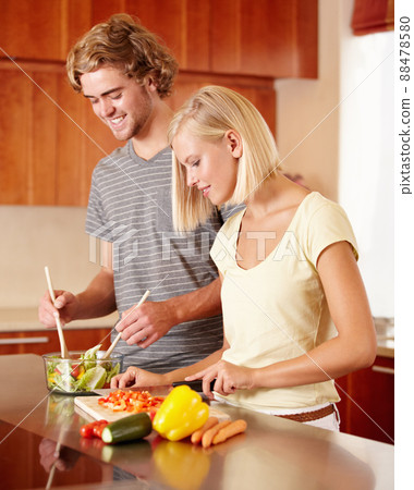 Making salad. A young couple preparing some food in the kitchen. Making salad. A young couple preparing some food in the kitchen. 88478580