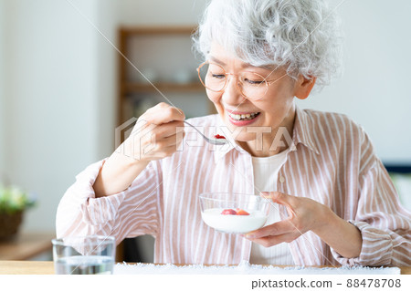 Senior woman eating yogurt 88478708
