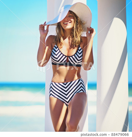 Shes all sunshine and smiles. Cropped portrait of a young woman posing in her bikini. Shes all sunshine and smiles. Cropped portrait of a young woman posing in her bikini. 88479066
