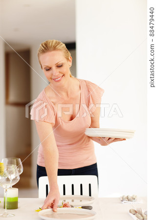 Making my guests feel special. A beautiful woman setting the table at home. Making my guests feel special. A beautiful woman setting the table at home. 88479440