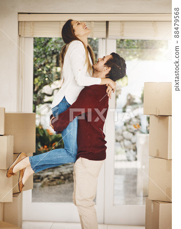 Their new home will be full of love. Cropped shot of an affectionate young couple embracing while moving into a new home. Their new home will be full of love. Cropped shot of an affectionate young couple embracing while moving into a new home. 88479568