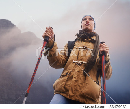 I CAN. Low-angle view of a young female hiker with the mountain in the background. I CAN. Low-angle view of a young female hiker with the mountain in the background. 88479681