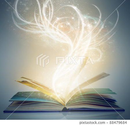Worlds of magic and mystery lie within its pages. A book on an isolated background with a bright,magical glow emanating from it. 88479684