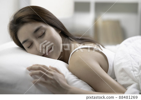 Young beautiful woman sleeping in her bed and relaxing in the morning Young beautiful woman sleeping in her bed and relaxing in the morning 88481269