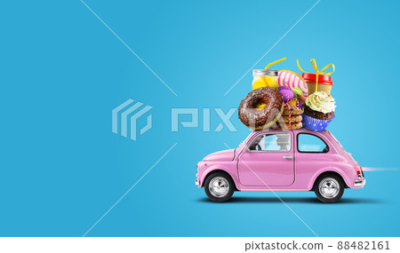 Pink retro car with Cakes, sweets, pastries a top on a blue Pink retro car with Cakes, sweets, pastries a top on a blue 88482161