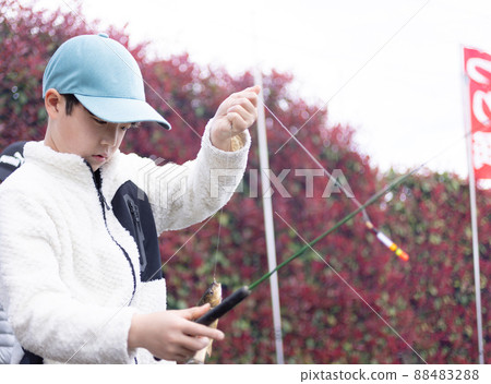 Children enjoying fishing in the fishing pond Children enjoying fishing in the fishing pond 88483288