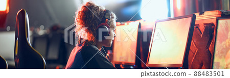 Cybersport concept. Side view of a focused teenage girl, professional gamer wearing headphones participating in eSport tournament 88483501