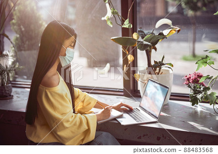 Asian woman working on laptop in cafe during quarantine Asian woman working on laptop in cafe during quarantine 88483568