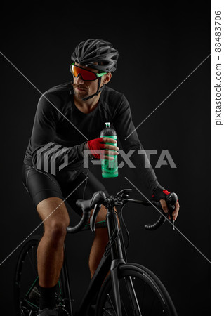 male cyclist riding road bicycle on black background male cyclist riding road bicycle on black background 88483706