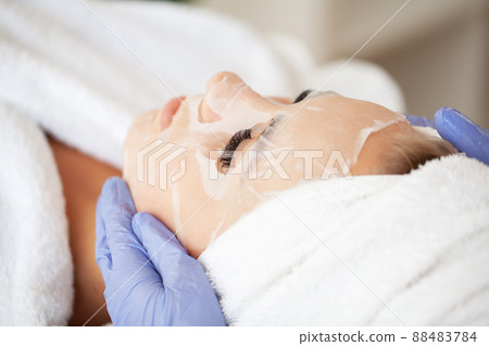 Young beautiful girl receiving facial mask in spa beauty salon 88483784
