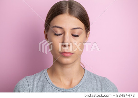 Portrait of a woman with closed eyes on a pink background Portrait of a woman with closed eyes on a pink background 88484478