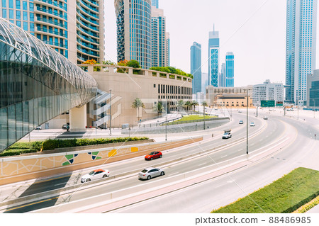 Cars moving on street among glass skyscrapers in Dubai. Traffic on street in Dubai. Cars moving at street. Modern with skyscrapers architecture of Dubai in sunny day. UAE. Cityscape skyline. Urban 88486985