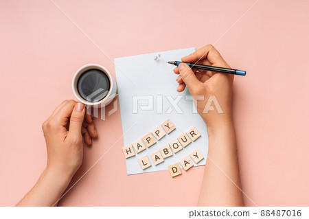 Hands holding pen and cup of coffee on paper 88487016