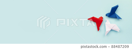 three paper origami pigeons red, white, blue on light background 88487209