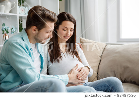 Couple expecting a baby while husband caresses the belly of his pregnant woman.. 88487550