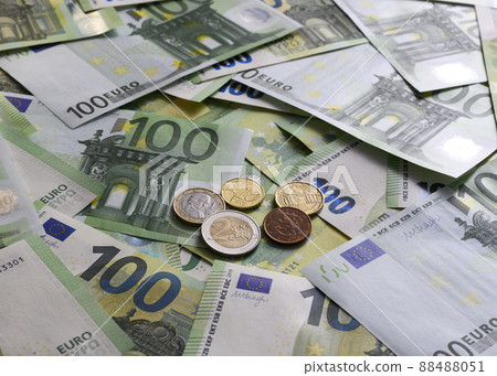 Euro cent coins on the background of 100 Euro banknotes arranged in random order 88488051
