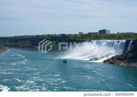 NIAGARA FALLS, ONTARIO, CANADA - MAY 20th 2018: View of the American Falls is the second-largest of the three waterfalls that together are known as Niagara Falls on the Niagara River along the Canada NIAGARA FALLS, ONTARIO, CANADA - MAY 20th 2018: View of the American Falls is the second-largest of the three waterfalls that together are known as Niagara Falls on the Niagara River along the Canada 88490094
