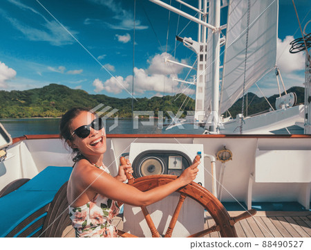 Cruise ship vacation happy tourist woman laughing steering ships wheel on deck for fun. Tahiti French Polynesia travel destination Cruise ship vacation happy tourist woman laughing steering ships wheel on deck for fun. Tahiti French Polynesia travel destination 88490527