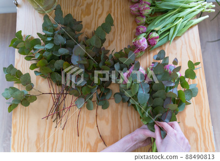 Close-up - a professional florist creates a bouquet of fresh flowers. Small business. Sale of plants in a retail store Close-up - a professional florist creates a bouquet of fresh flowers. Small business. Sale of plants in a retail store 88490813