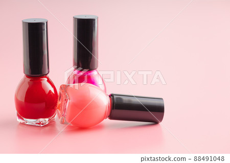 Colorful nail polish bottles on pink background. 88491048