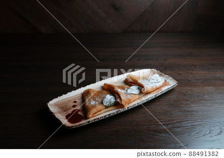 Thin sweet hot pancakes with sweet jam on a plate in a restaurant. Delicious dessert for tea. Thin sweet hot pancakes with sweet jam on a plate in a restaurant. Delicious dessert for tea. 88491382