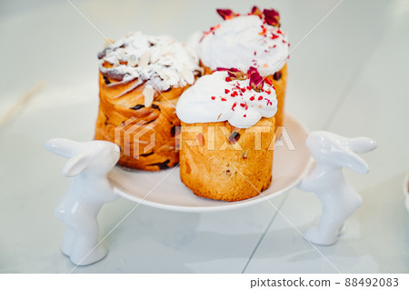 decorated panettones and cruffins on serving plate with rabbits. easter cakes. decorated panettones and cruffins on serving plate with rabbits. easter cakes. 88492083