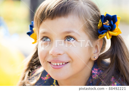 Flag Day of Independence of Ukraine. Stop WAR. Ukrainian girl in an embroidered vyshyvanka shirt with a yellow-blue flag of Ukraine. Symbols of the flag of Ukraine. Freedom. Russia terror. Kyiv.  88492221