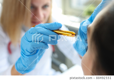 Doctor ophthalmologist shines light in patient eyes Doctor ophthalmologist shines light in patient eyes 88492331