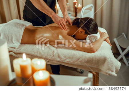 Half naked relaxed woman getting back spine massage at beauty spa resort 88492574