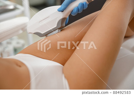 Woman with smooth skin getting legs epilation with ipl machine in beauty salon 88492583