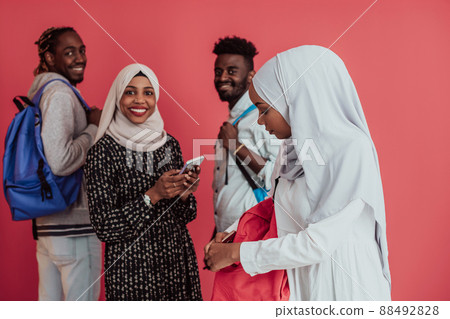 A group of African Muslim students with backpacks posing on a pink background. the concept of school education. 88492828