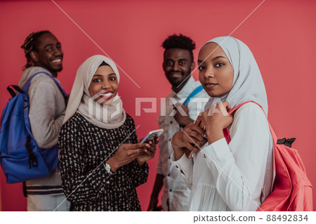 A group of African Muslim students with backpacks posing on a pink background. the concept of school education. 88492834
