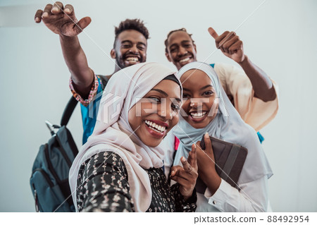A group of multiethnic students take a selfie with a smartphone on a white background. Selective focus A group of multiethnic students take a selfie with a smartphone on a white background. Selective focus 88492954