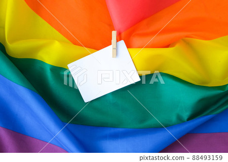 Rainbow flag with empty paper note copy space. Rainbow lgbtq flag made from silk material. Symbol of LGBTQ pride month. Equal rights. Peace and freedom 88493159