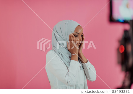 Modern African Muslim woman makes traditional prayer to God, keeps hands in praying gesture, wears traditional white clothes, has serious facial expression, isolated over plastic pink background Modern African Muslim woman makes traditional prayer to God, keeps hands in praying gesture, wears traditional white clothes, has serious facial expression, isolated over plastic pink background 88493281