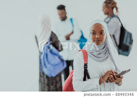 African female student with group of friends in background wearing traditional Islamic hijab clothes. Selectve focus African female student with group of friends in background wearing traditional Islamic hijab clothes. Selectve focus 88493348