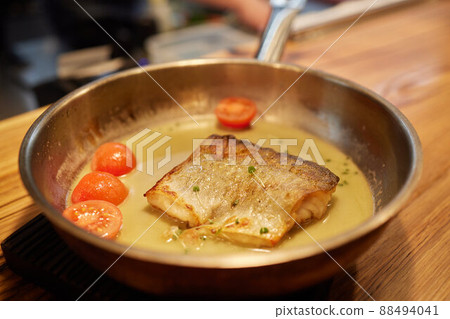 Dish of fish fillet with salad on dripping pan close up. 88494041