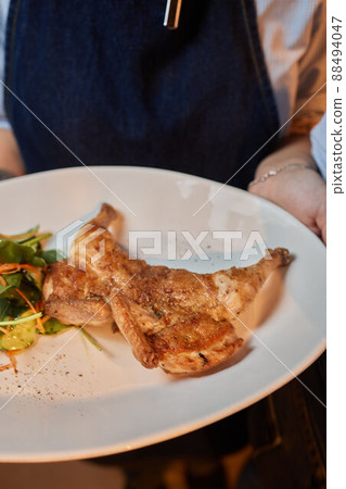 grilled tobacco chicken on a white plate. grilled tobacco chicken on a white plate. 88494047