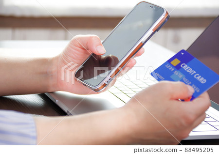 A woman with a smartphone and a credit card A woman with a smartphone and a credit card 88495205
