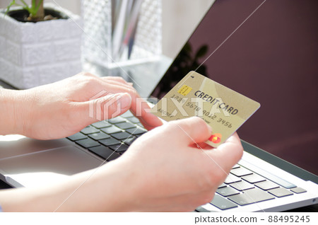 一位女士在她的電腦上輸入信用卡信息 88495245