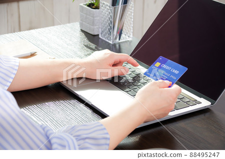 一位女士在她的電腦上輸入信用卡信息 88495247